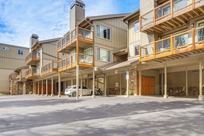 A multi-story hotel with outdoor balconies, a covered parking area, and a stone facade. - Walk to Ski & Main St! Newly Refinished w/ Hot Tub (Breckenridge)