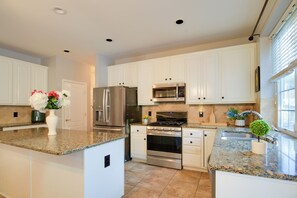 A modern kitchen with white cabinetry, stainless steel appliances, granite countertops, and a central island. - 4 Mi to Dtwn Bel Air & Trails! Grand Home (Bel Air)