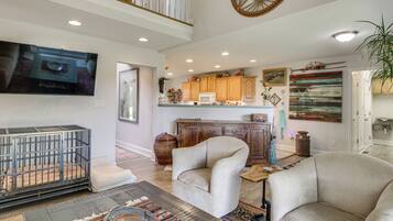 A spacious living room with a large television, a sofa, and a coffee table.