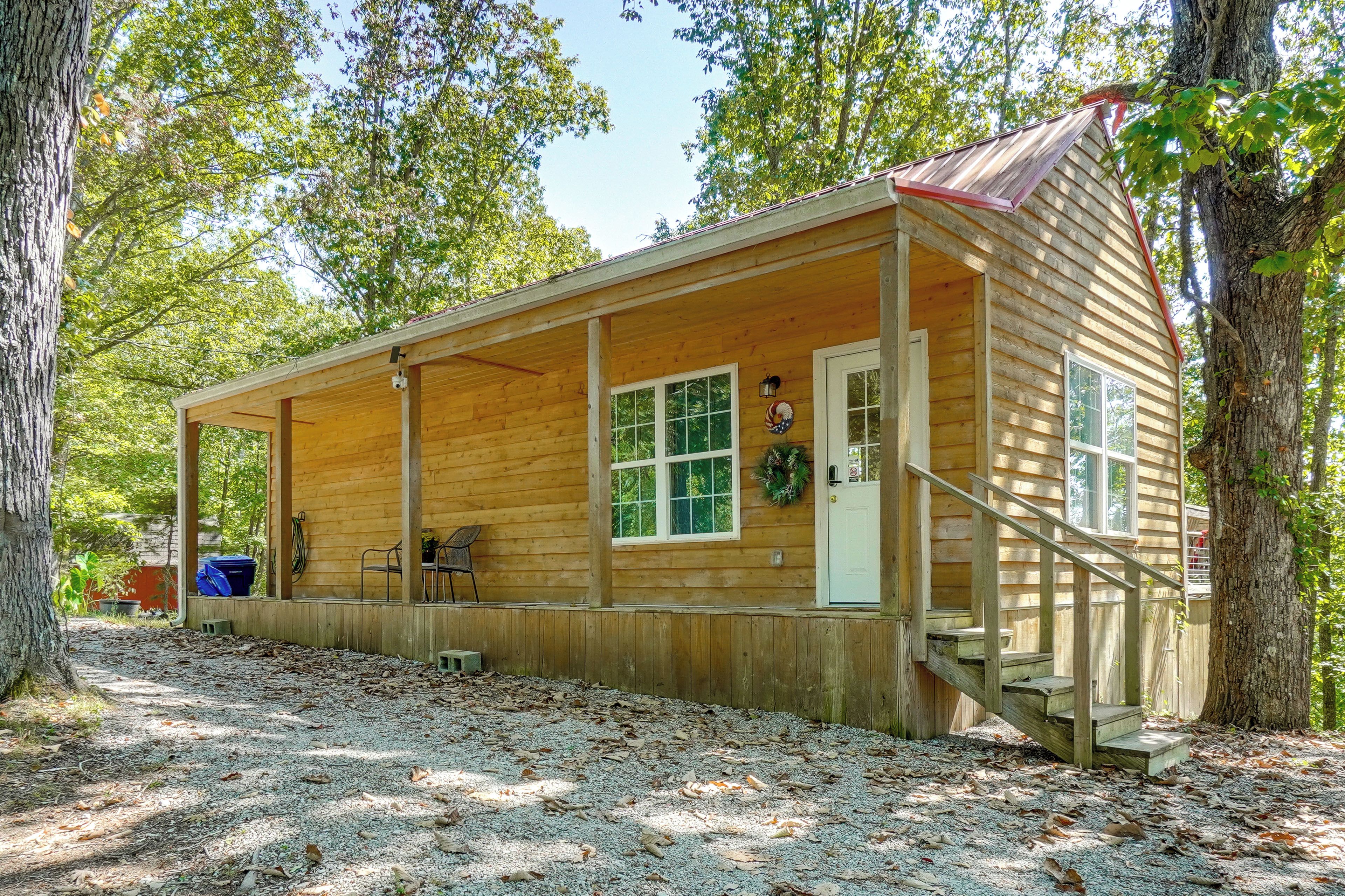 Une cabane en bois avec une véranda, une porte et une fenêtre.