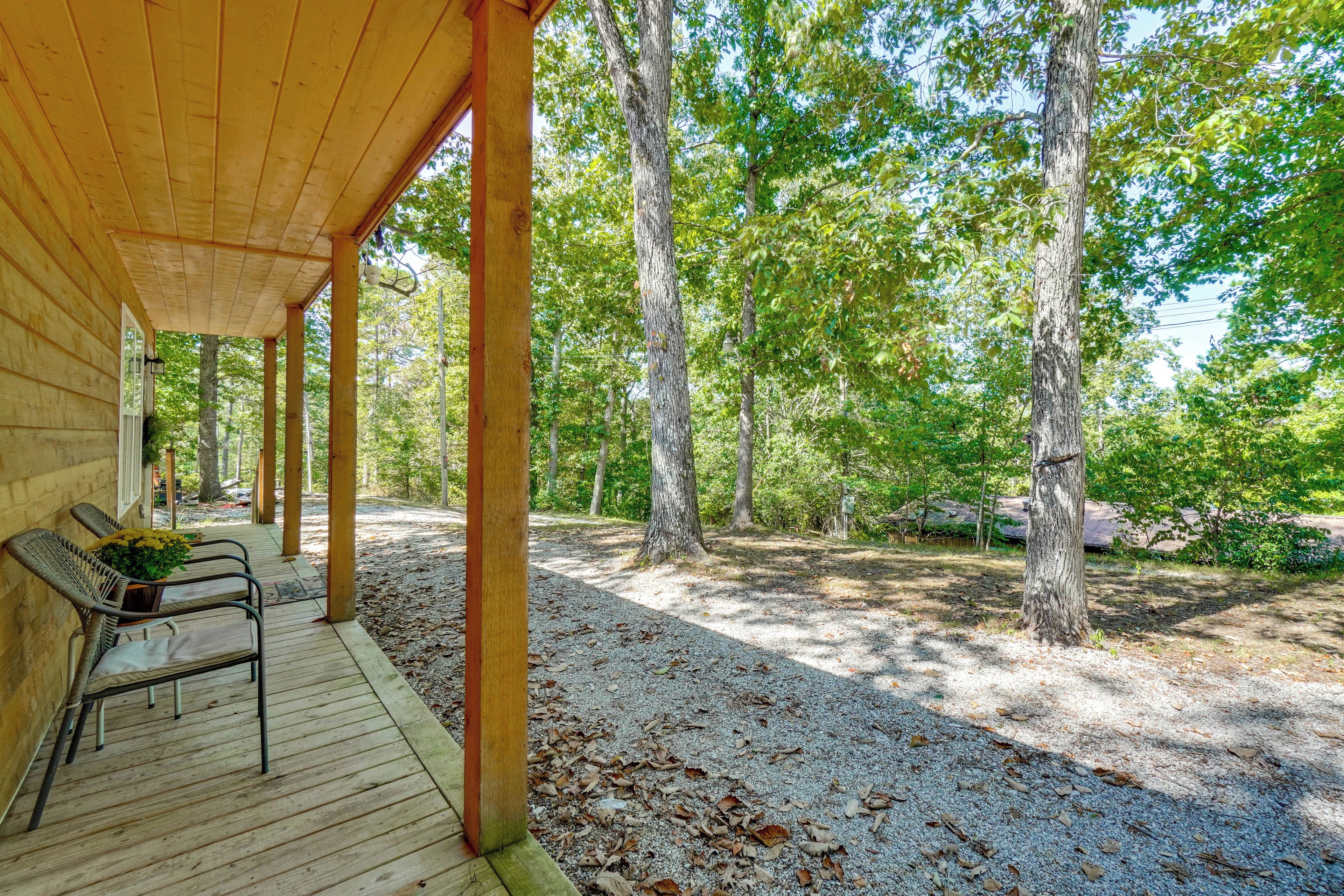 A covered outdoor seating area with wooden benches and a gravel path.