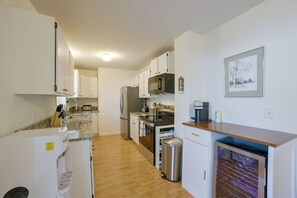 A modern kitchen with white cabinets, stainless steel appliances, a built-in oven, and a coffee maker. - Walk to Lake & Downtown! 6 Mi to Boyne Mtn (Boyne City)