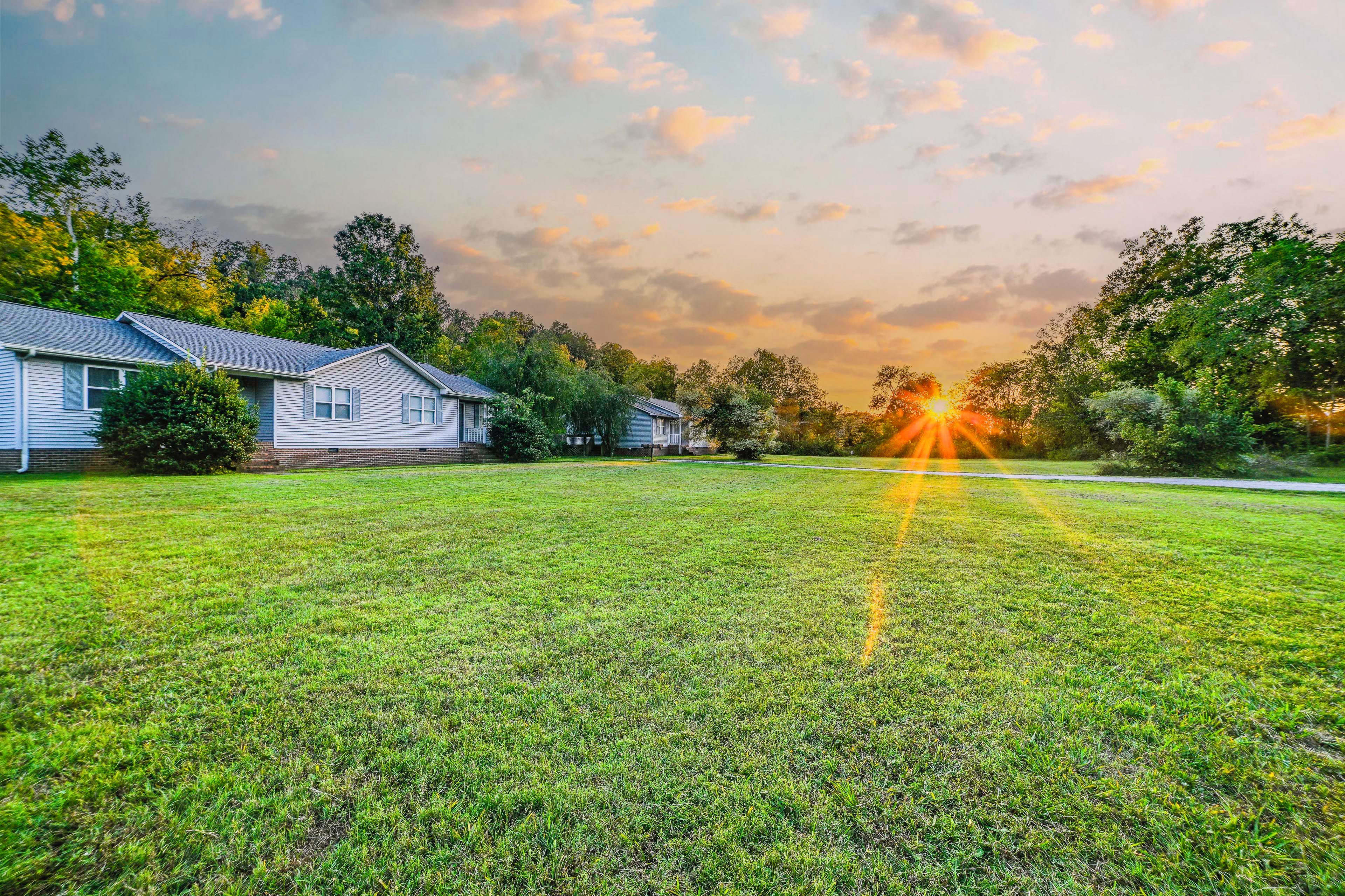 A residential area with houses, a grassy lawn, and trees.