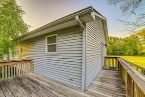 A house with a wooden deck, a window, and a door.