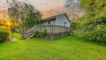 A house with a wooden deck and a staircase leading to the front door.