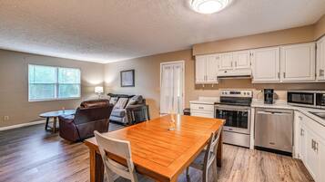 A modern kitchen with white cabinets, a built-in oven, microwave, and dishwasher.