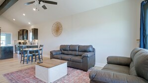 Ein modernes Wohnzimmer mit einem grauen Sofa, einem weißen Couchtisch und einem gemusterten Teppich.