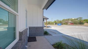 A building with a large glass window, a concrete entrance, and a parking lot with a stop sign.