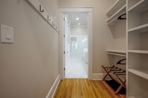 A hallway with a wooden floor, white walls, and a white door leading to a bathroom. - Main St Magic: Walkable Salisbury Condo! (Salisbury)