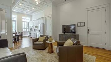 A modern living room with a sofa, a coffee table, and a television.