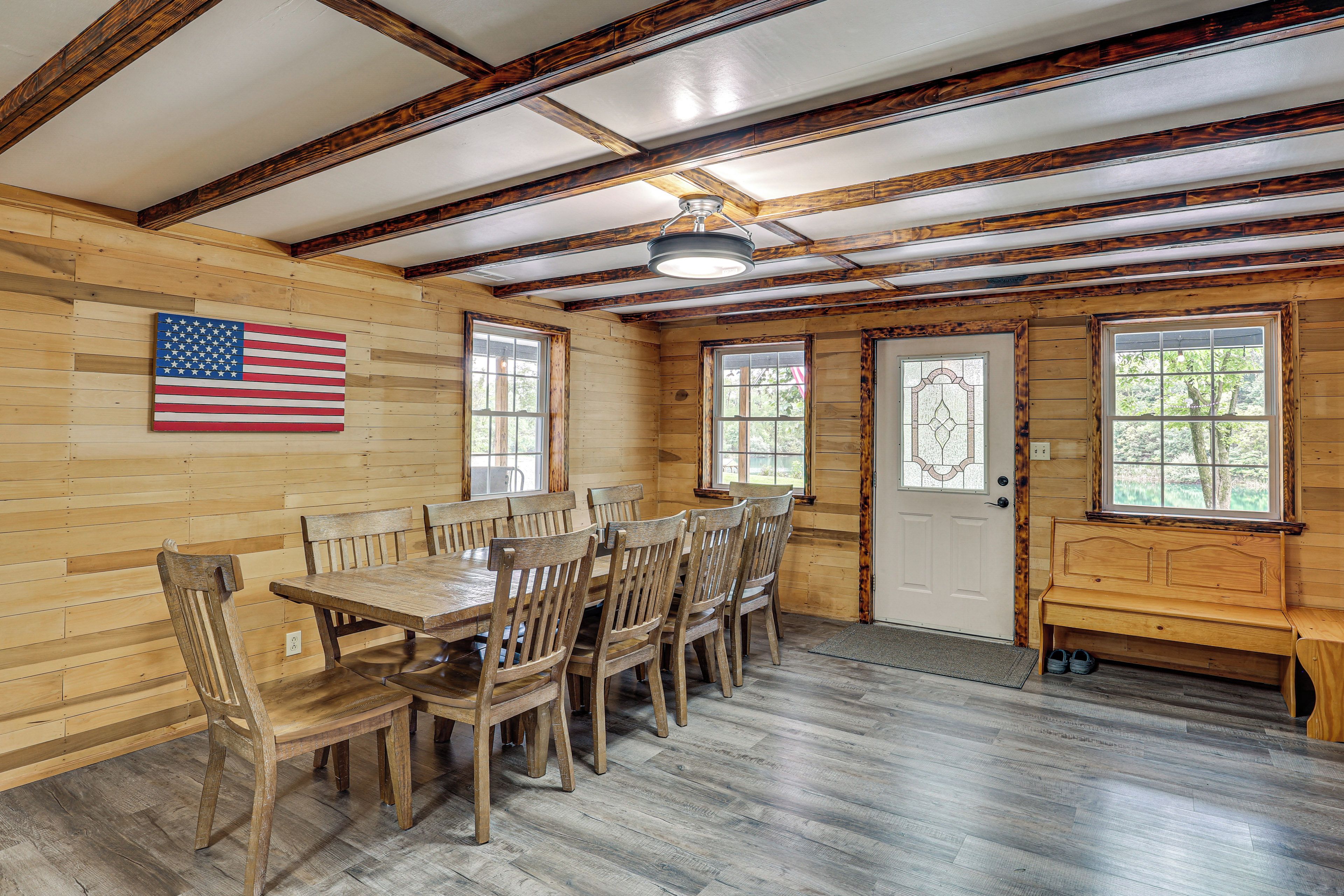 A wooden interior with a dining table, chairs, and a bench.