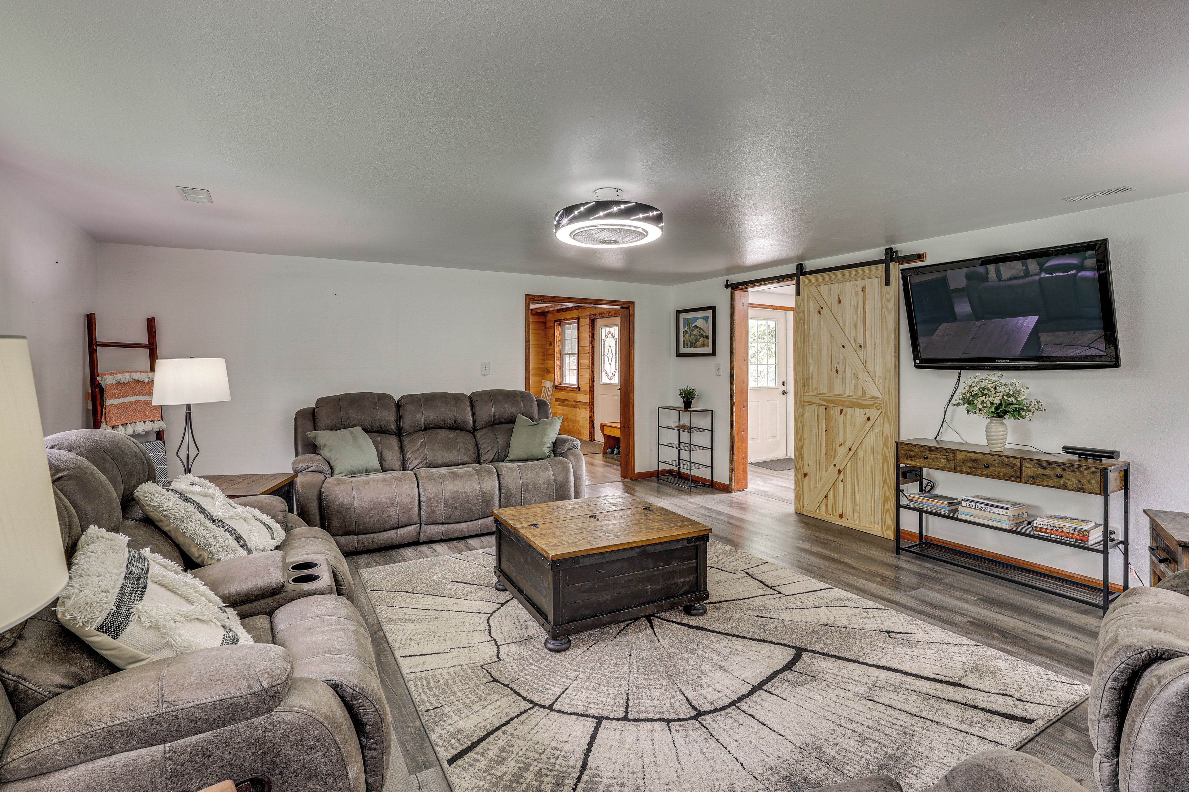A living room with a sectional sofa, a coffee table, a TV, and a bookshelf.