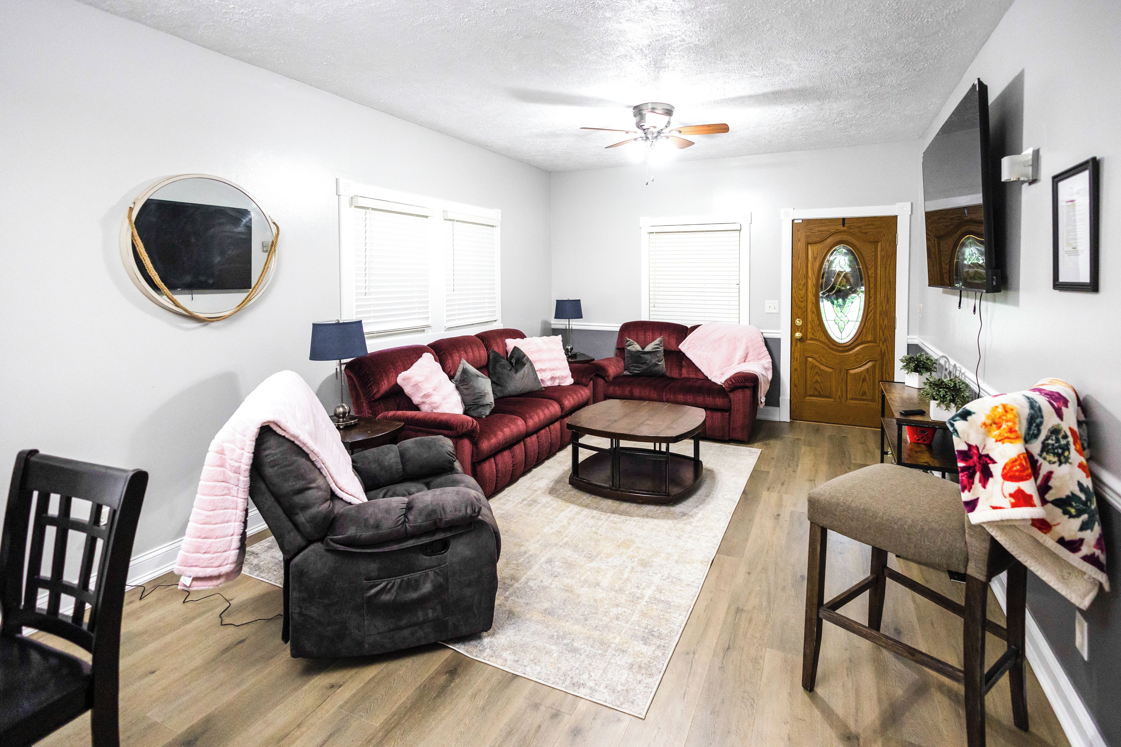 A living room with a sectional sofa, a loveseat, a coffee table, and a dining area with a chair and table.