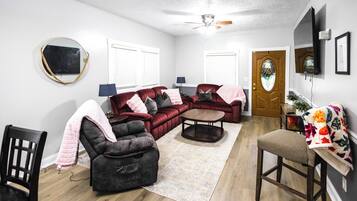 A living room with a sectional sofa, a loveseat, a coffee table, and a dining area with a chair and table.