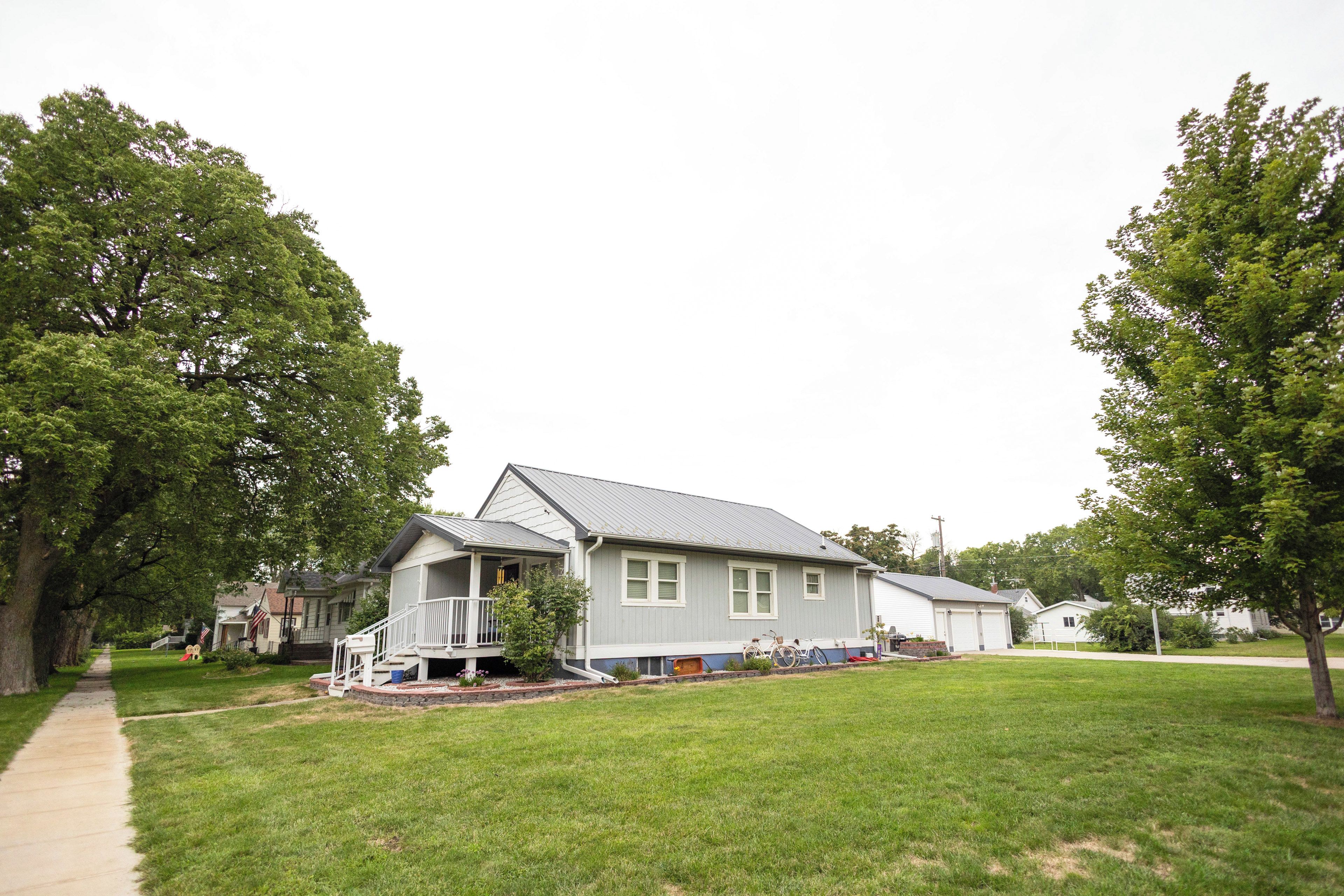 A two-story house with a porch, a garage, and a well-maintained lawn.