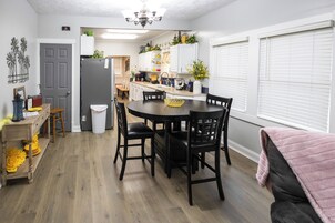 Una cocina compacta con una mesa de comedor, sillas y un refrigerador.
