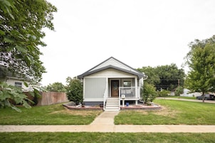 A single-story house with a front porch, a small front yard, and a visible mailbox.