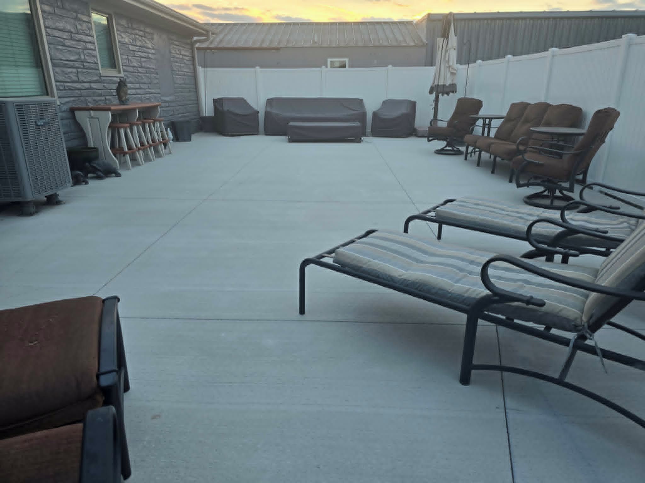A patio area with lounge chairs and a barbecue grill.