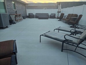 A patio area with lounge chairs and a barbecue grill.
