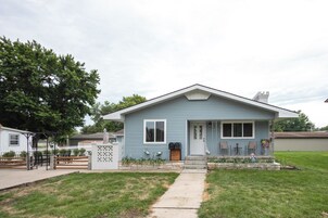 A single-story house with a front porch, a mailbox, and a small garden area.