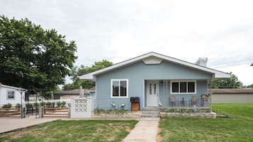 A single-story house with a front porch, a mailbox, and a small garden area.