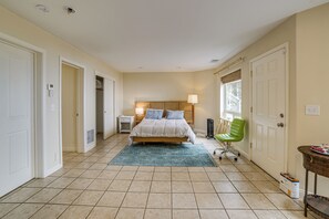 Una habitación de hotel con cama, mesita de noche, lámpara, silla y ventana.