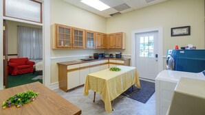 A compact kitchen with wooden cabinets, a microwave, and a washing machine. - Walkable Main Street Apartment in Princeton! (Princeton)