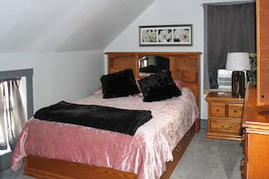 A bedroom with a bed, a dresser, a mirror, and a window. - The Hide Out - a Family Getaway in Columbus (Columbus)