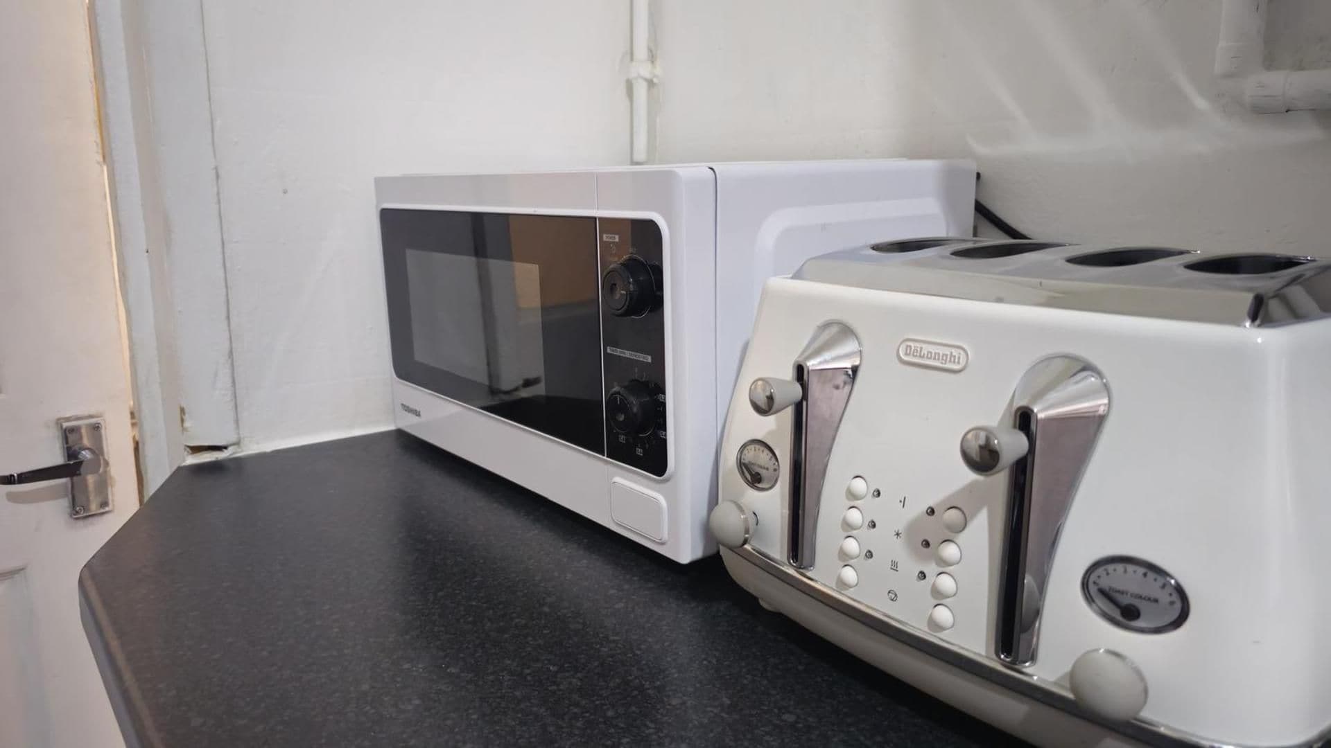 Un microondas y una tostadora sobre una encimera.