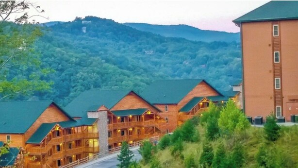 A multi-story lodge with a green roof, surrounded by forested hills. - 2-bedroom resort in superb Gatlinburg with fitness room, jetted bath tubs, w/AC (Gatlinburg)