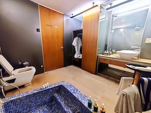 A modern bathroom with a large bathtub, a toilet, and a shower area. - Mana Hotel Ranakpur (Desuri)