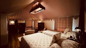 Una habitación con una colcha estampada, una lámpara colgante y un techo con diseño.