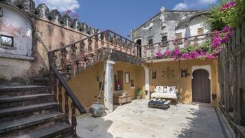 Un patio con escalera, cama y puerta.