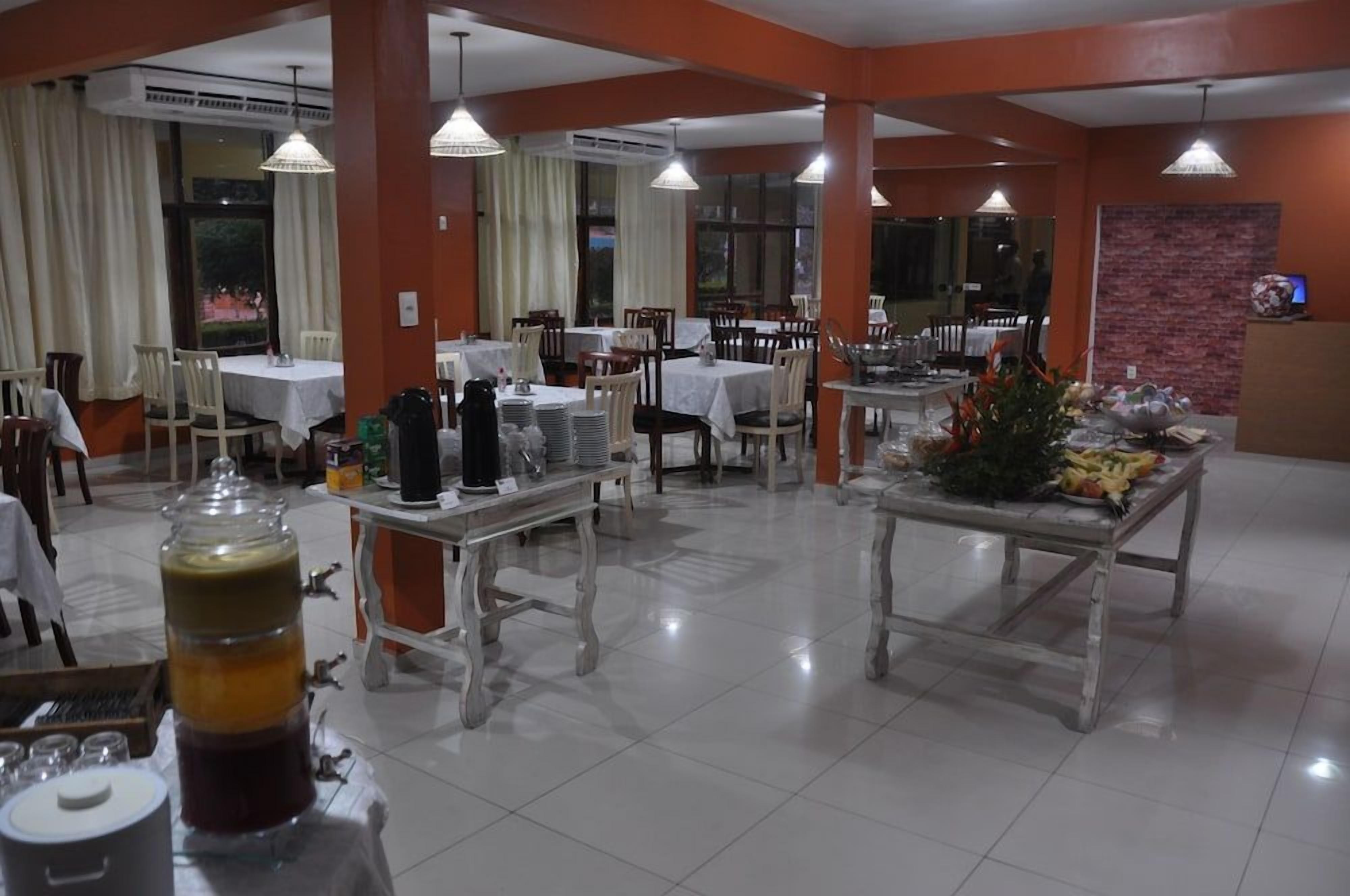 A dining area with multiple tables and chairs, air conditioning units, and a buffet setup.