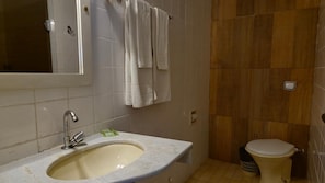 A bathroom with a sink, mirror, and toilet. - Real Minas Suites Hotel (Governador Valadares)