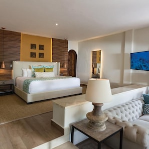 Ein modernes Hotelzimmer mit einem großen Bett, einer Couch, einer Lampe und einem Fernseher.