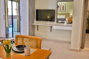 A hotel room with a dining area, a television mounted on the wall, and a view of the outside. - Luxury stay at Degla by Spacey #67 (Cairo)