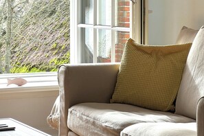 A room with a window, a cushion, and a small table. - Your comfortable apartment, Alter Konsumverein, Apartment 1, in a central location on Sylt (Sylt)