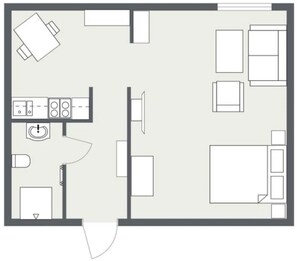 Plano de un cuarto de hotel con kitchenette, cama, baño y zona de estar.