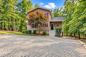 A two-story house with a gravel driveway and a small front porch. - 🌊 Beechnut Cove | Lake Gaston Escape • Private Dock • Game Room • Fire Pit 🔥 (Littleton)