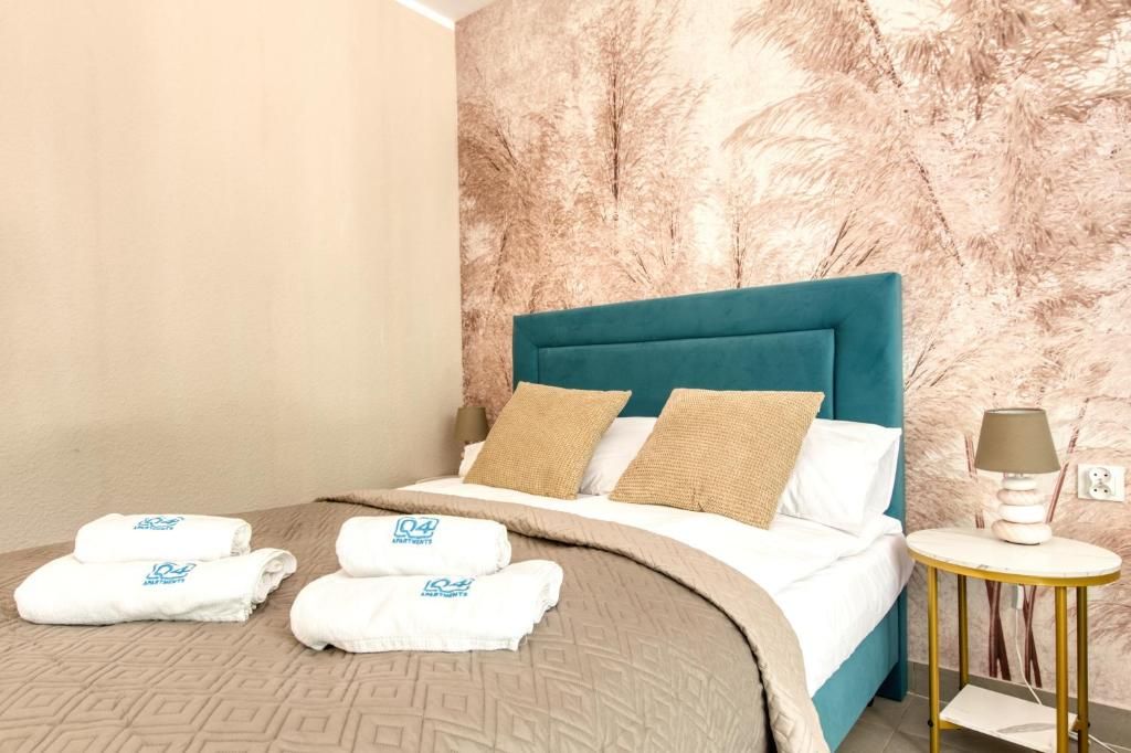 Ein Hotelzimmer mit einem Bett, einem runden Beistelltisch und einer Wand mit einer strukturierten Oberfläche.