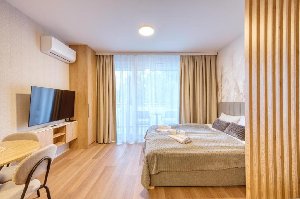 Une chambre d’hôtel avec un lit, une télévision, un bureau et une chaise.