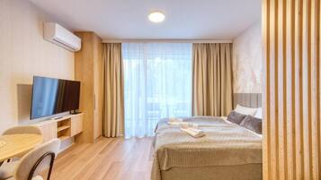 Une chambre d’hôtel avec un lit, une télévision, un bureau et une chaise.