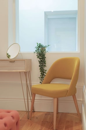 A room with a yellow chair, a wooden desk with a mirror, and a plant by a window. - Downtown Balcony Studio II (Porto)
