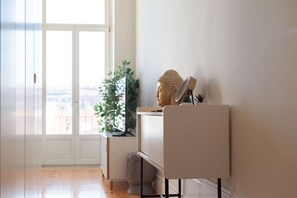 Habitació minimalista amb escriptori, estàtua de Buda i planta en test.