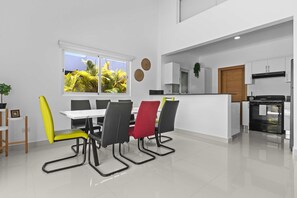 A modern kitchen with white cabinets, a black oven, and a wooden door. - Modern 3BR Villa With Private Pool in Oasis del Lago by Vistacana Rentals (Punta Cana)