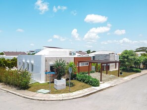 Zona residencial con casas modernas, una calle pavimentada y cielo despejado.