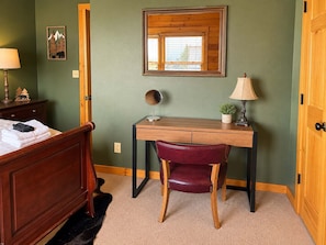 A bedroom with a wooden bed, a desk with a chair, a mirror, and a window. - Ski-out to Hatley Pointe Hot Tub Sleeps 8 (Mars Hill)
