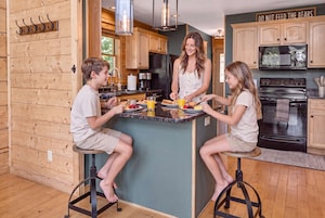 A modern kitchen with wooden cabinetry, a central island, and a stainless steel oven.