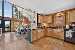 A spacious kitchen with wooden cabinets, a large island, and a view of the outdoors. - Ski-out to Hatley Pointe Hot Tub Sleeps 8 (Mars Hill)